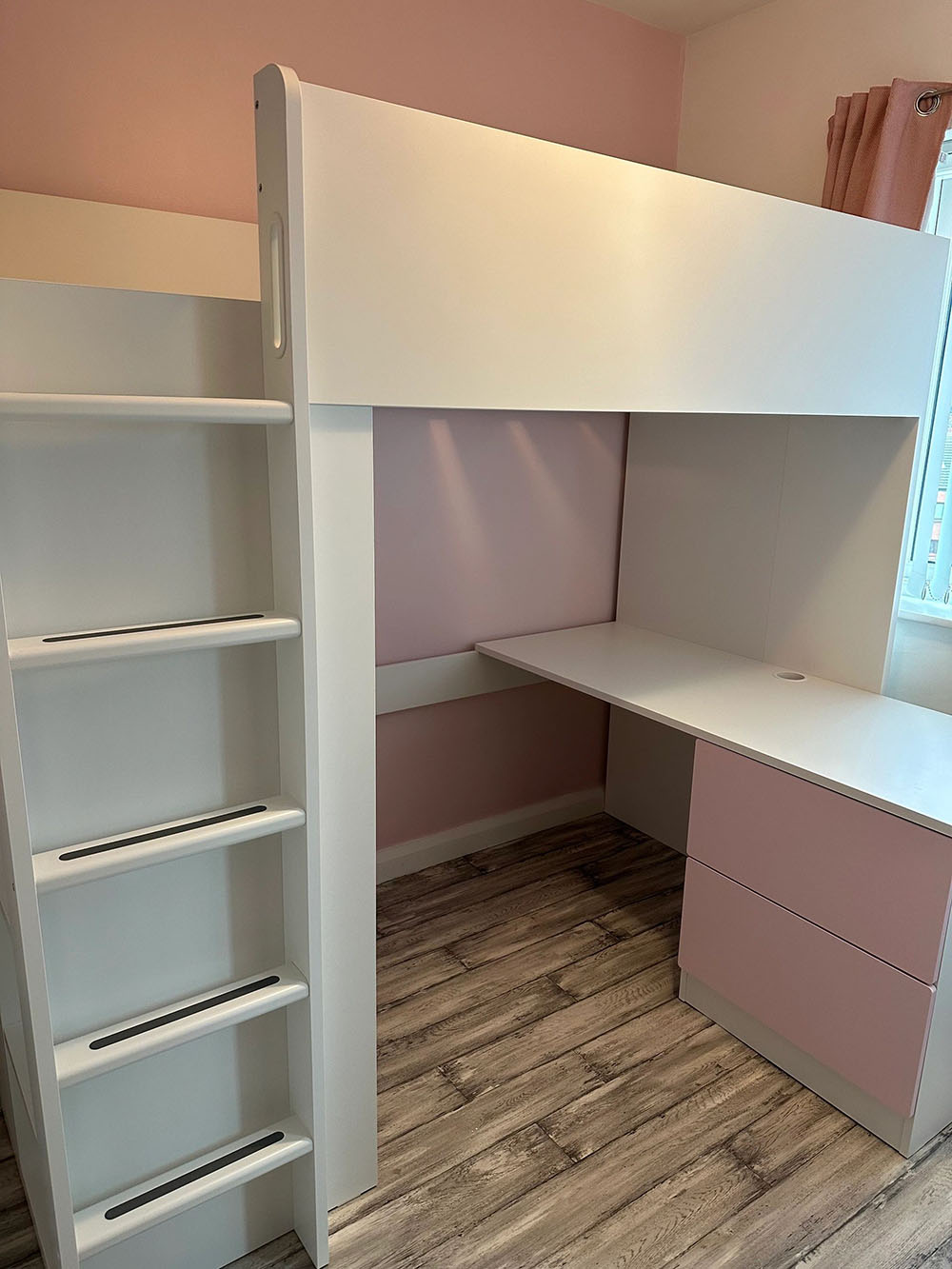 Pink and white bunk bed with desk